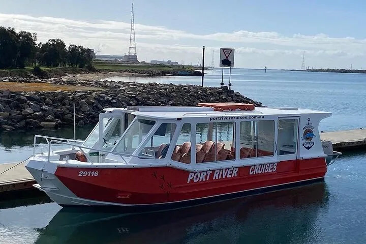 A red and white Port River Cruises boat docked at a pier